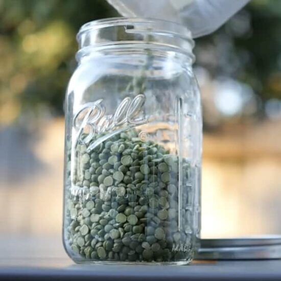 pouring split peas lentils into wide mouth mason jar for zero waste shopping