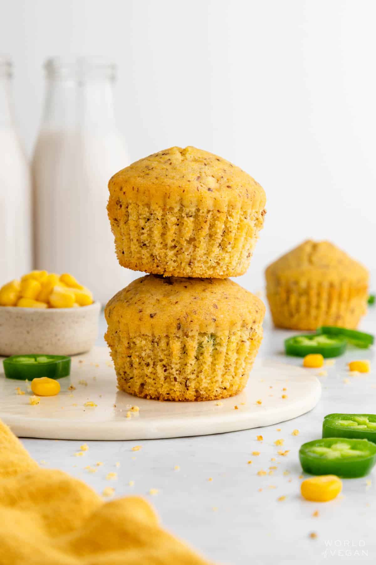 Vegan cornbread muffins stacked on a plate.