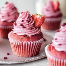 Pink and red cupcakes topped with strawberry frosting.