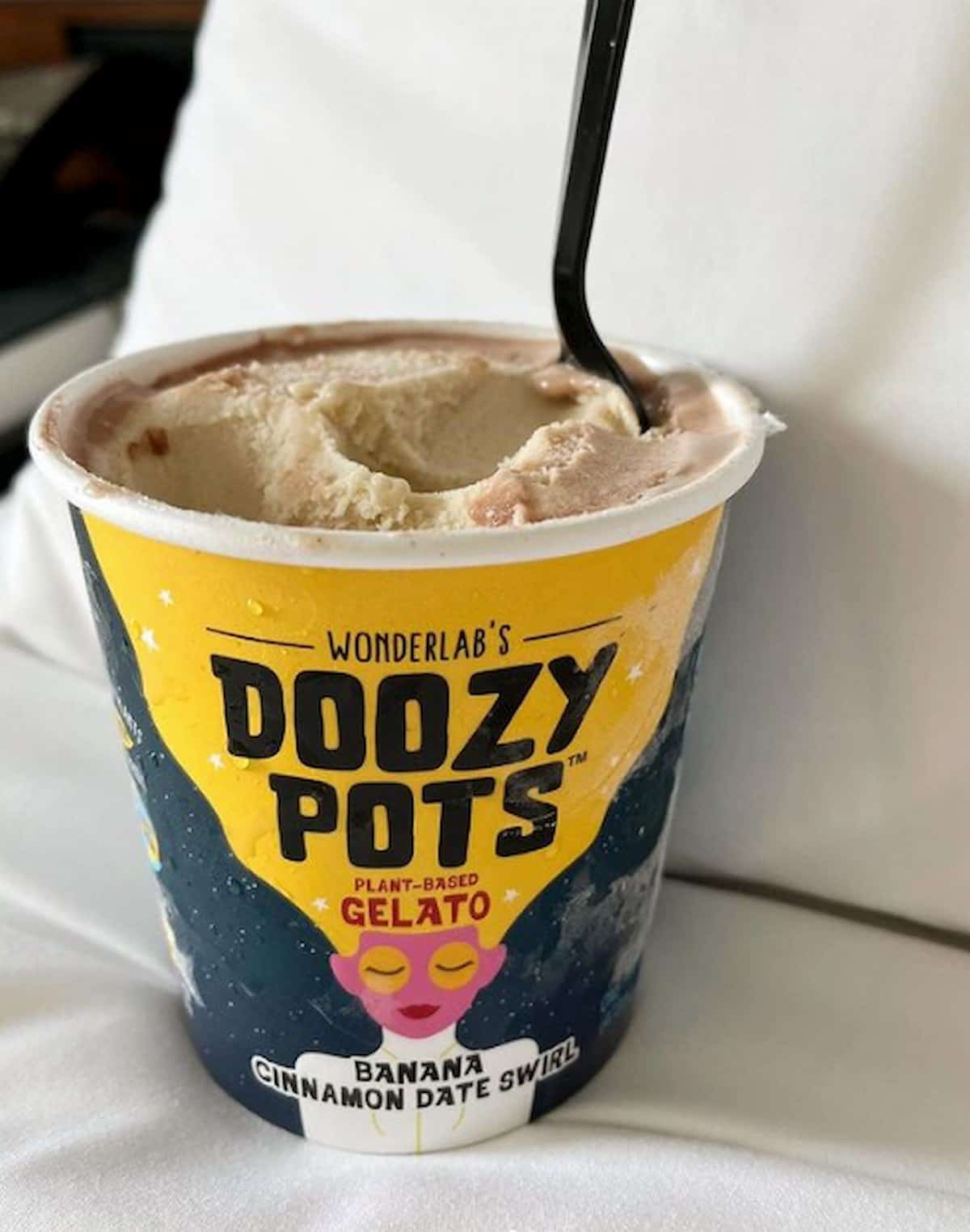 An open pint of Wonderlab's Doozy Pots banana cinnamon date swirl plant-based gelato with a spoon.