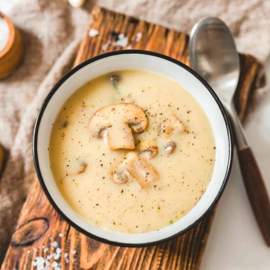 Easy Vegan Cashew Cream of Mushroom Soup in a Bowl on a Wood Cutting Board