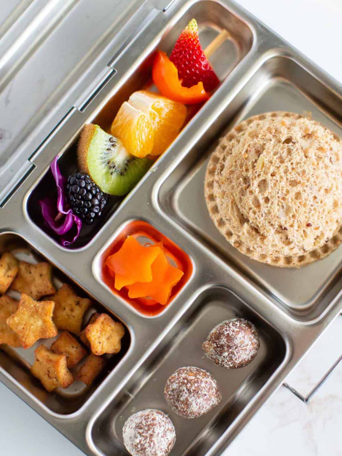 Planet Box stainless steel zero waste vegan kids lunchbox with fruit kebabs.