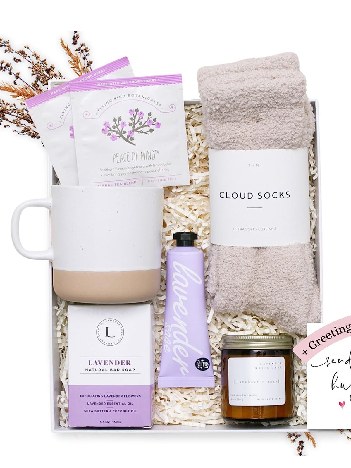 A get well gift basket with a soy candle, vegan lotion, cozy socks, a mug, and tea.