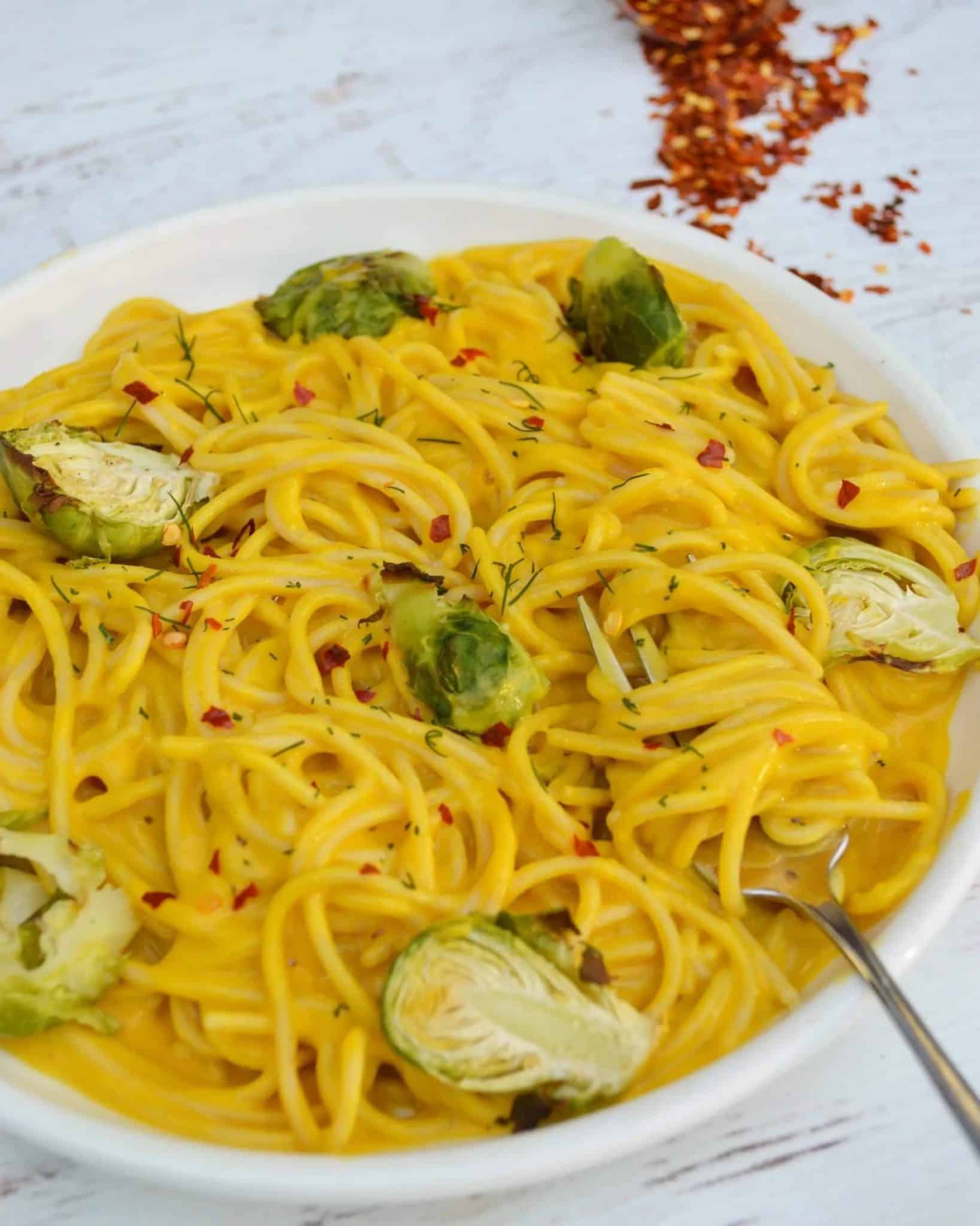 spaghetti noodles in kabocha squash sauce with brussels sprouts and red pepper flakes