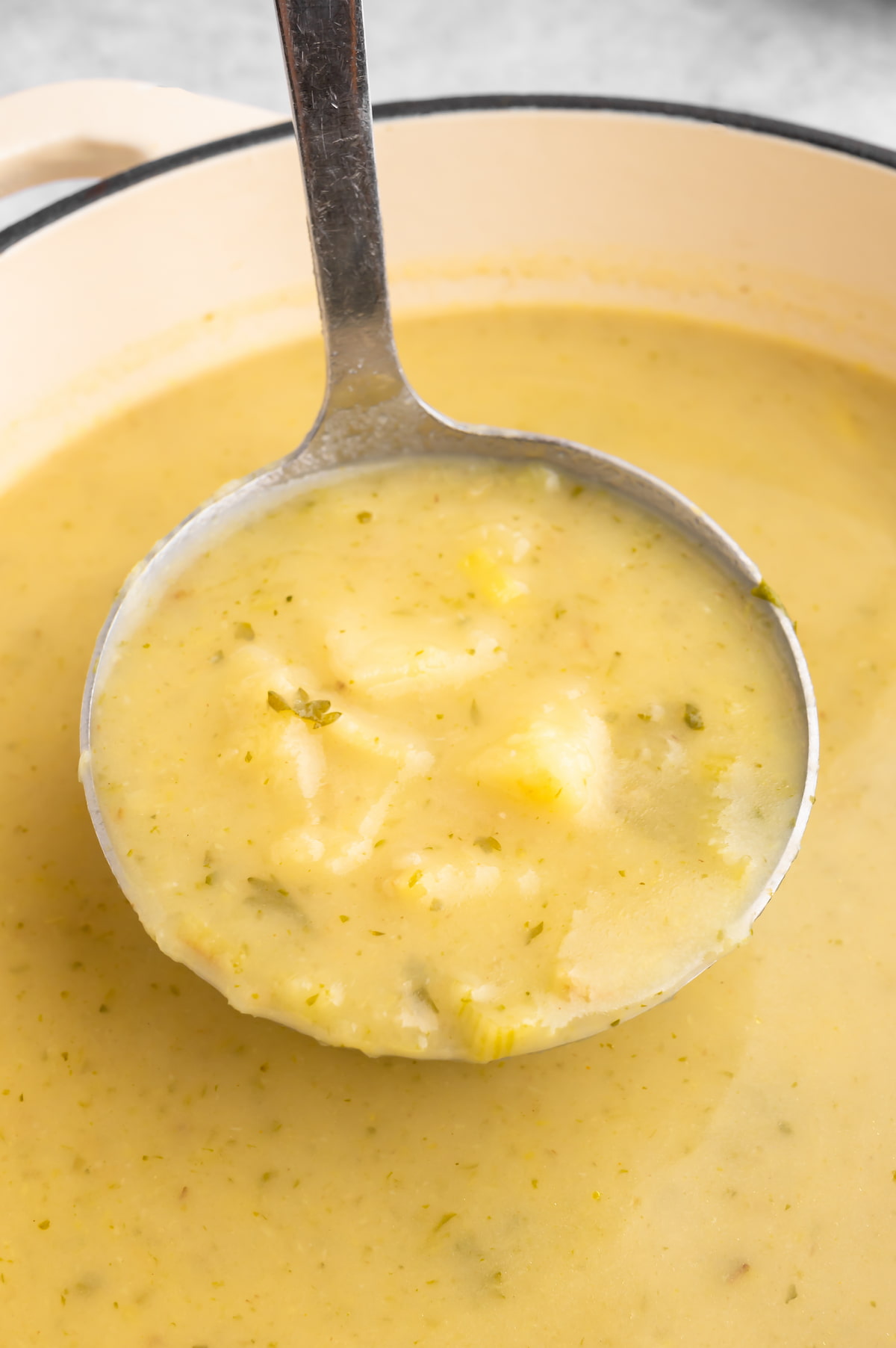 Vegan potato leek soup in a ladle.