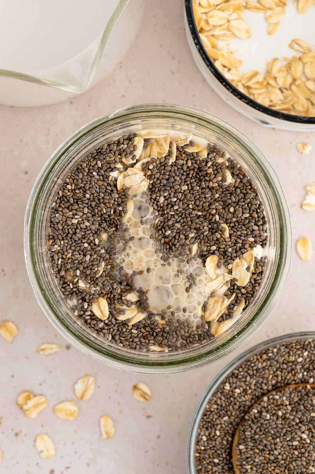 Ingredients for overnight oats added to a glass jar.