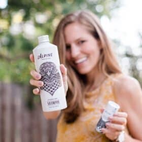 Michelle Cehn holding up cruelty-free and vegan sustainable body wash and shampoo from Alpine Provisions.