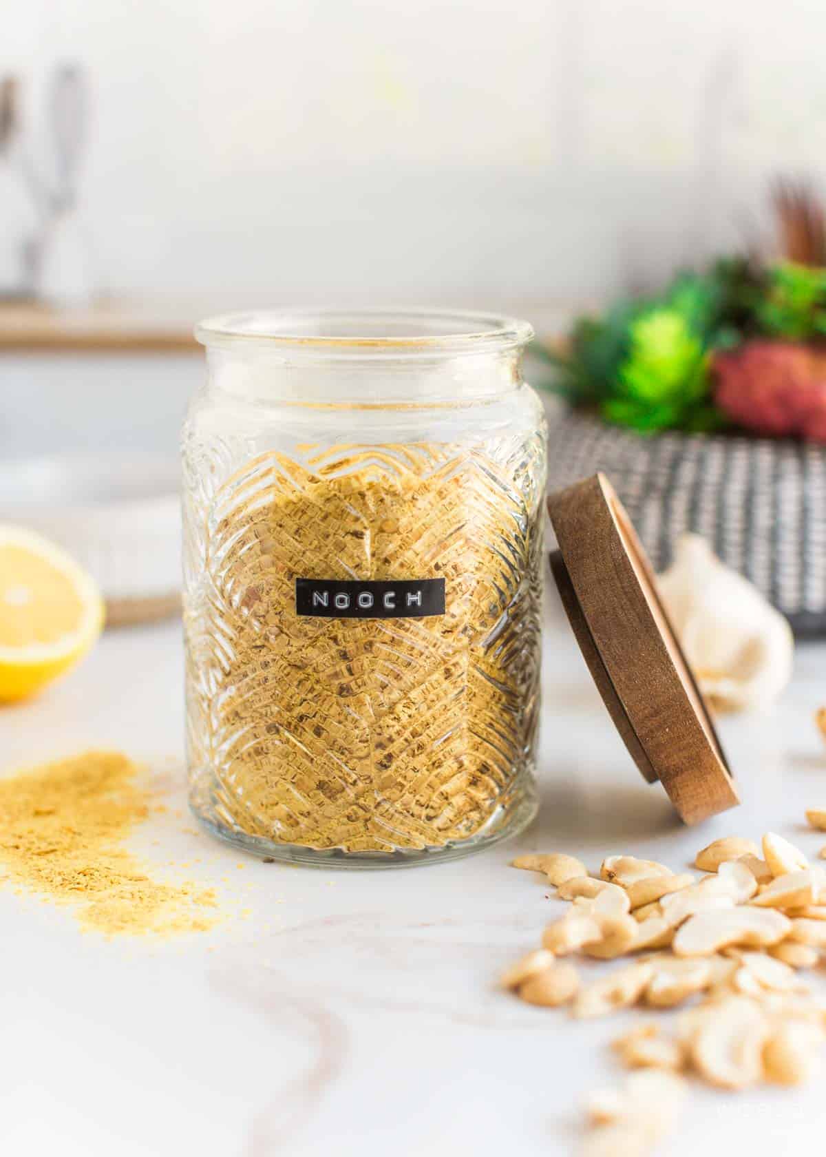 A jar labeled "nooch" and filled with nutritional yeast.