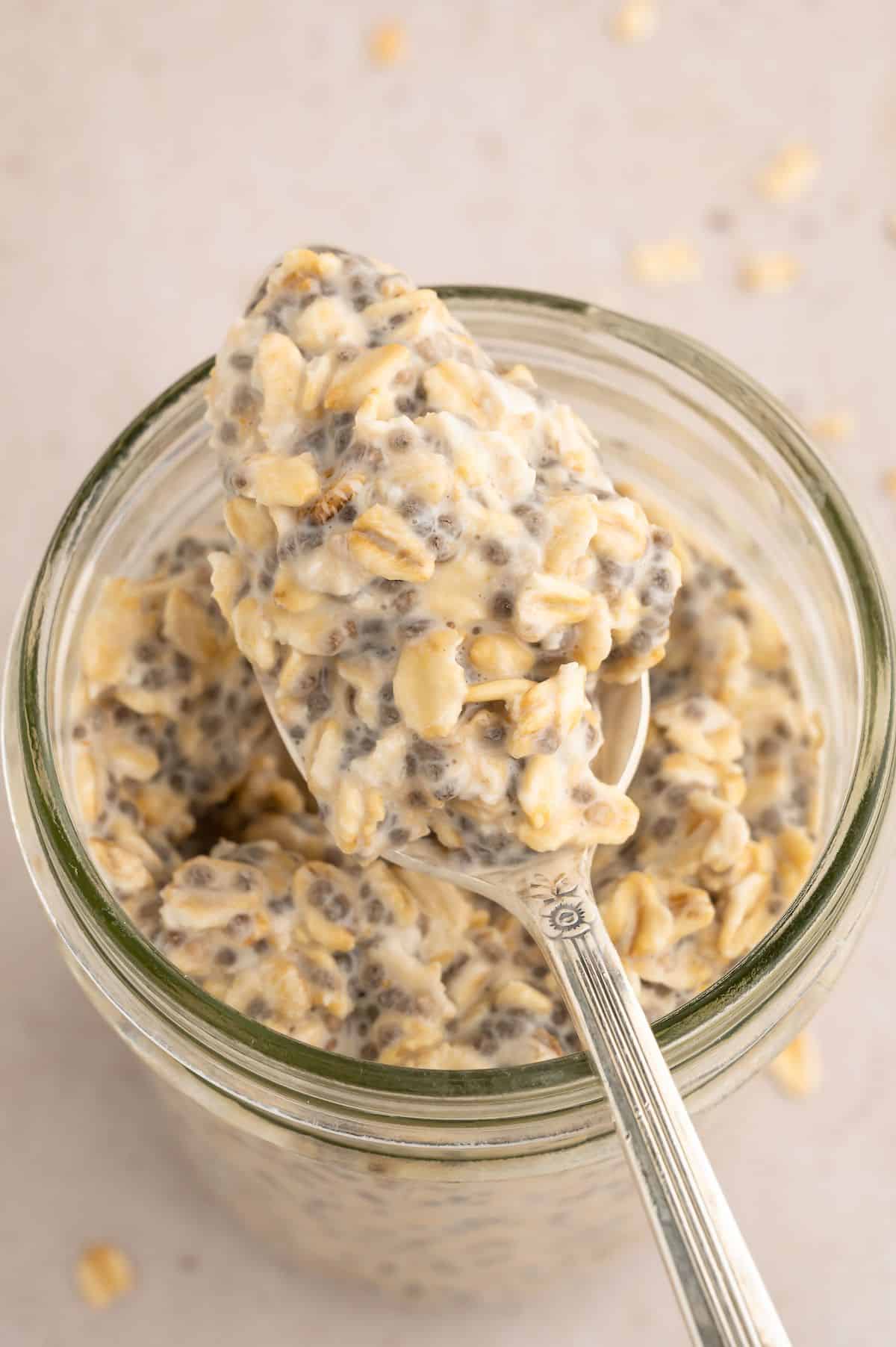 Overnight oats in a jar with a spoon resting on top holding a spoonful of overnight oats.