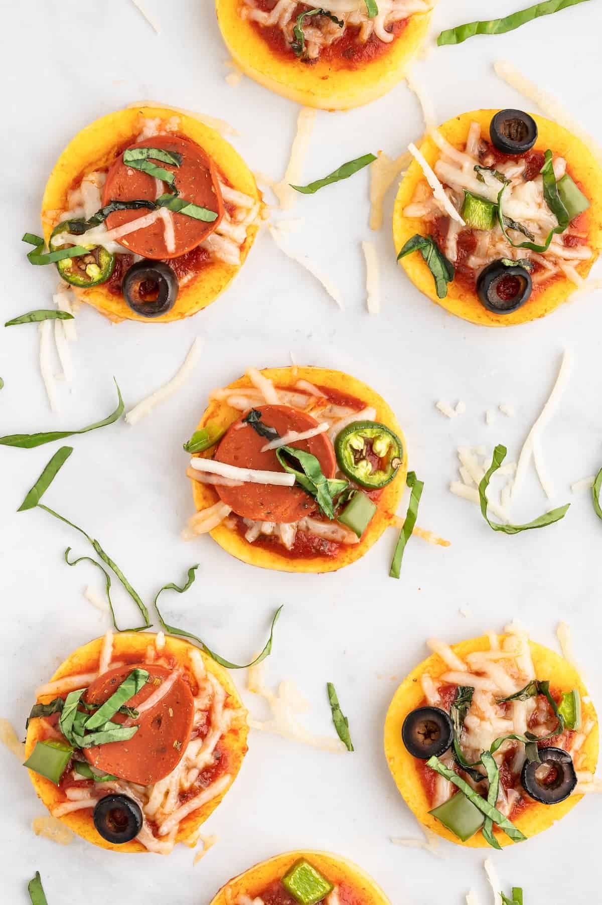 Polenta pizza bites, with melted vegan cheese abd toppings.