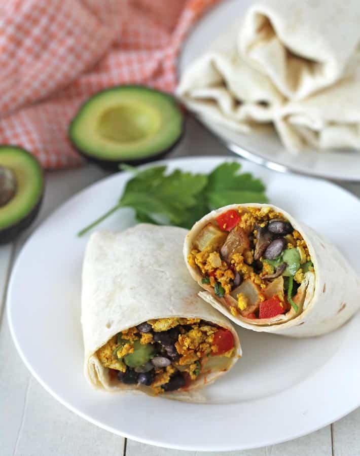 vegan tofu burrito filled with potatoes, bell peppers, black beans, and spinach