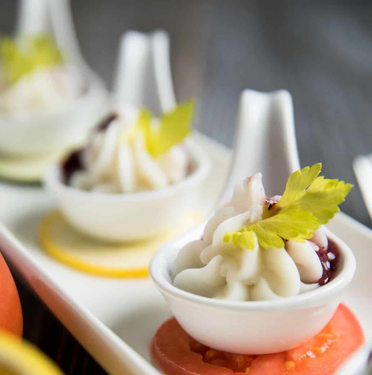 An image of vegan dumplings in serving spoons.
