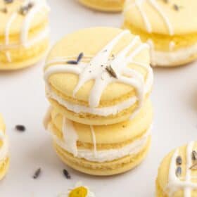 Two vegan macarons stacked with a drizzle of vegan white chocolate.
