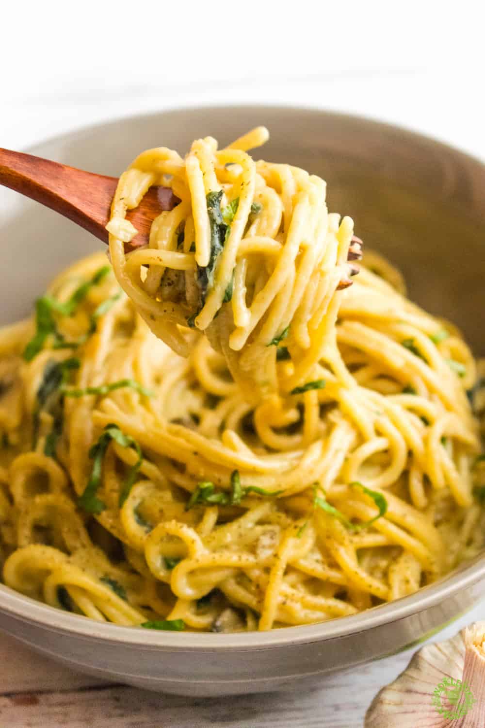 Creamy Vegan One Pot Pasta With Mushrooms and Basil Served in a large bowl being held up with a fork
