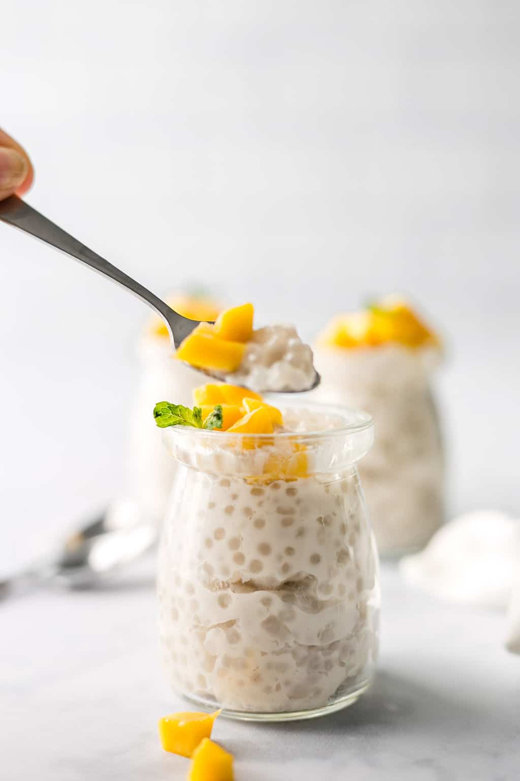 Vegan Tapioca Pudding topped with Mango in glass jar.