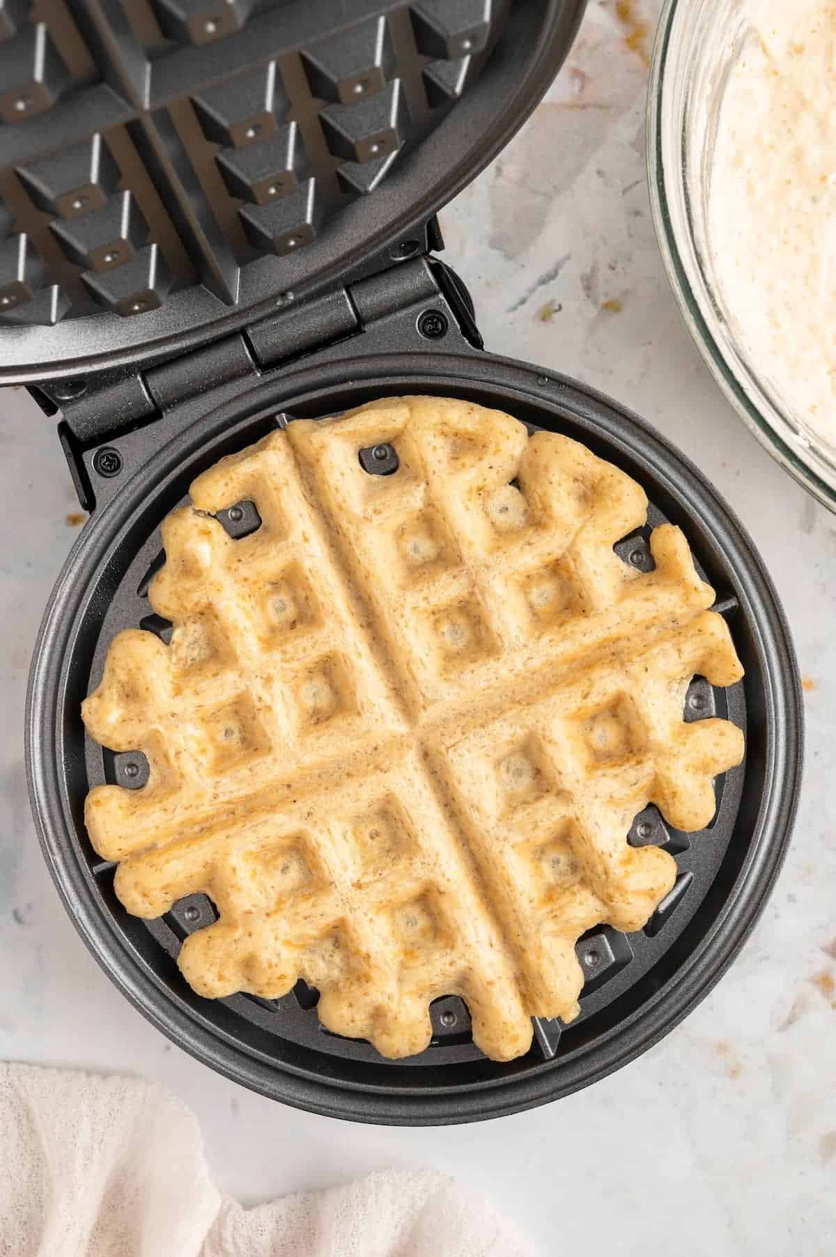 A vegan waffle in a waffle iron.